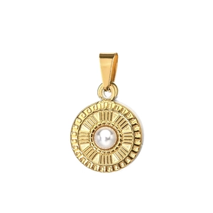 Close-up of a vintage golden sunburst pendant featuring a white pearl inlay and metal details