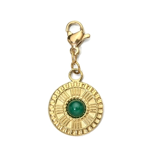 Macro shot of gold vintage pendant with green gemstone inlay and lobster clasp