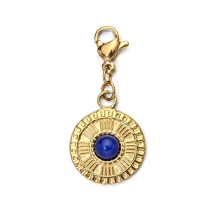 Macro shot of gold stainless steel pendant featuring a blue gemstone and lobster clasp