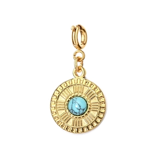 Macro shot of gold vintage pendant with turquoise stone inlay and sunburst engraving