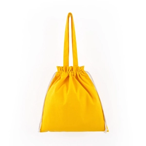 Detail of yellow canvas drawstring bag showing cotton rope and pleated closure design