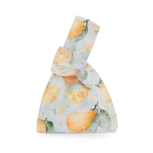 Detail of soft velvet knot wrist bag with watercolor lemon print and leaf pattern