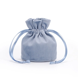 Detail of light blue velvet drawstring bag with soft texture and matching satin ribbons