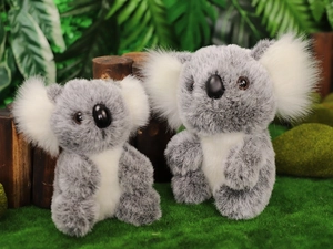 Dettaglio di due koala di peluche con orecchie soffici e pelliccia grigia su legno