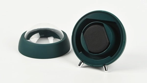 Detail of a dark green automatic watch winder with acrylic dome and black sponge pillow