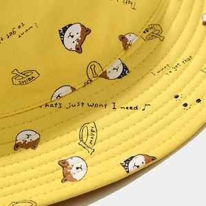 Détail d'un chapeau bob en toile jaune avec imprimé Shiba Inu et coutures précises