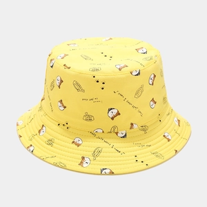 Détail d'un chapeau bob en toile jaune avec des motifs mignons de dessins animés Shiba Inu