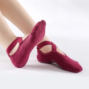 Non-slip cotton yoga socks with cross straps and grip dots in dark red for Pilates