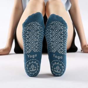 Blue yoga socks with grey anti-slip grips and Yoga text shown from a sole view perspective