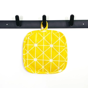 Square yellow thick cotton placemat with white grid pattern and hanging loop on white background
