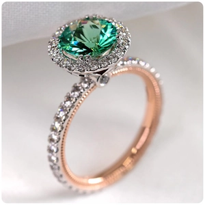 Luxurious green gemstone ring with halo diamonds and dual-tone gold milgrain finish