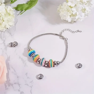 Rainbow striped DIY beads on silver snake chain bracelet with floral marble background