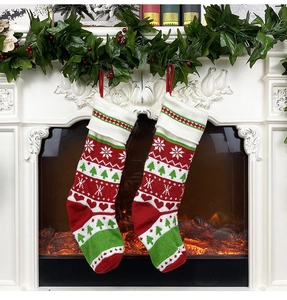 Close-up of red and white knit Christmas stockings with snowflake patterns on fireplace