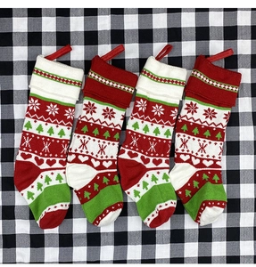 Detailed view of four knitted Christmas stockings with festive snowflake and tree patterns