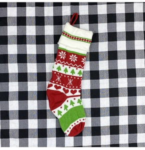 Detail of red and green knitted Christmas stocking with festive snowflake patterns