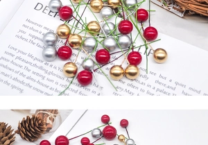 Close-up of red, gold and silver Christmas foam berries scattered with pine cones
