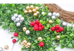 Detail of red and gold artificial Christmas berries with flexible wire stems for DIY decor