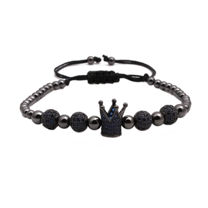 Detail of royal crown charm and blue zircon beads on adjustable woven bracelet
