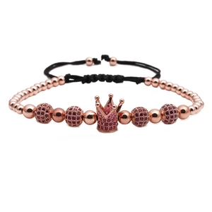 Detail of rose gold beaded bracelet featuring a pink zircon crown and adjustable black cord