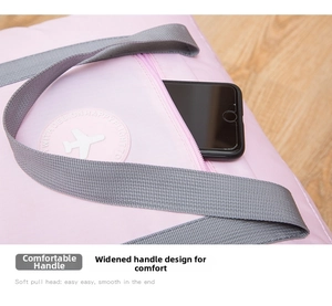 Detail of pink travel bag showing a front zip pocket and sturdy grey carry handles