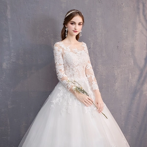 Elegante abito da sposa a maniche lunghe in pizzo con ricami e gonna in tulle soffice