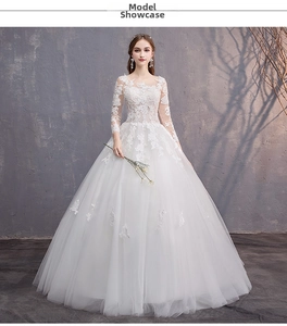 Dettaglio dell'abito da sposa bianco a maniche lunghe con eleganti ricami in pizzo