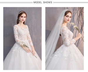 Dettaglio dell'abito da sposa in pizzo bianco con ricami floreali e maniche lunghe