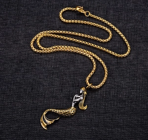 Detailed shot of a two-tone mermaid pendant in gold and silver on a box chain