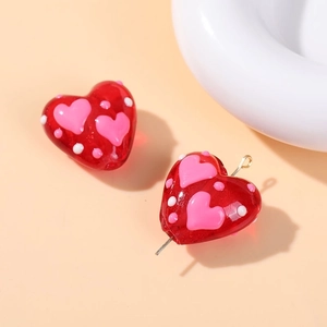 Macro shot of red heart-shaped glass beads with pink hearts and white polka dots for DIY