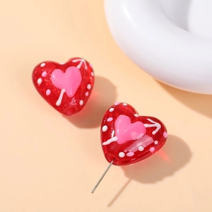 Macro view of red heart-shaped glass beads with polka dots for DIY jewelry making