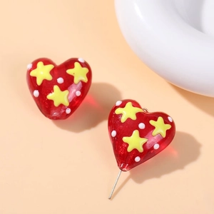 Macro shot of red heart glass beads with yellow stars and white polka dots for jewelry