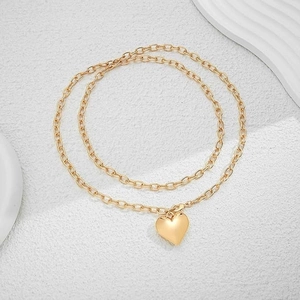 Close-up of golden double-layered heart pendant necklace with polished finish