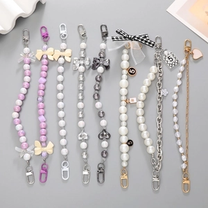 Detail of luxury shoe charms featuring pearls, metal chains and rhinestone pendants
