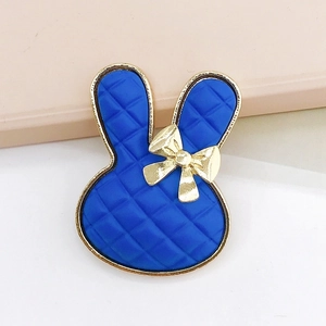 Macro view of blue checkered bunny DIY accessory with gold bow and quilted texture