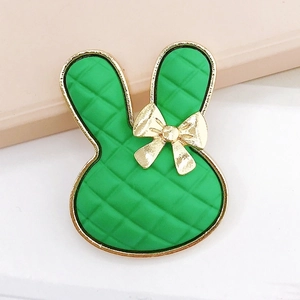 Detail of green rabbit charm with quilted texture and gold metallic bow detail