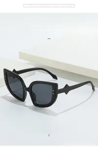Detailed macro view of black cat-eye sunglasses featuring silver metal rivet decorations