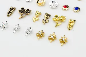 Macro shot of 3D metal rose flower nail charms with pearls and colorful rhinestones