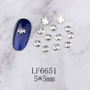 Detail of silver alloy 5x5mm flower nail charm with central sparkling white rhinestone