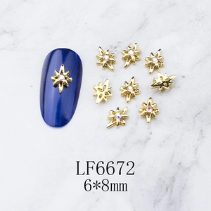 Detail of 6x8mm gold alloy star nail charms with sparkling rhinestone inlay on blue nails