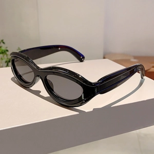 Detail showing the glossy black cat-eye sunglasses frame on a minimalist white stand