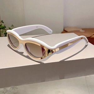 Detail view of retro cat-eye sunglasses with white frames and gold metal accents