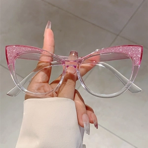 Detail of pink cat-eye glasses frame featuring glitter accents and translucent plastic finish