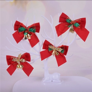 Red Christmas bows with gold bells and holly leaves on a decorative reindeer stand