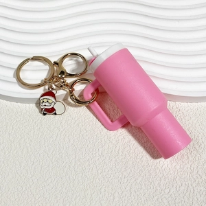 Pink mini vacuum cup keychain with golden hardware and small Santa Claus charm detail
