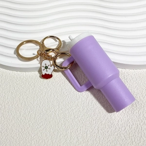 Detail of purple mini tumbler keychain with festive glove charm and golden ring