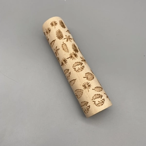 Macro view of laser-engraved floral and leaf patterns on a wooden rolling pin