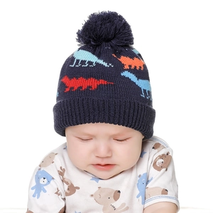 Detail of baby dinosaur knit hat with navy wool texture and soft cotton lining