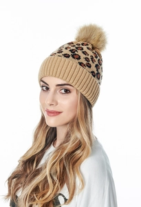 Close-up of leopard print knit beanie featuring a large fluffy faux fur pom-pom detail