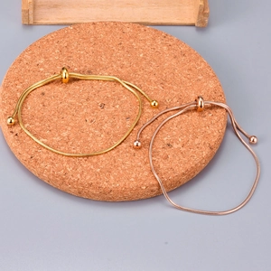 Detail of adjustable snake chain bracelets in gold and rose gold with slider beads