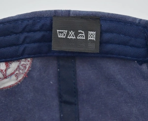Macro shot of 100% cotton wash label and internal stitching of navy baseball cap